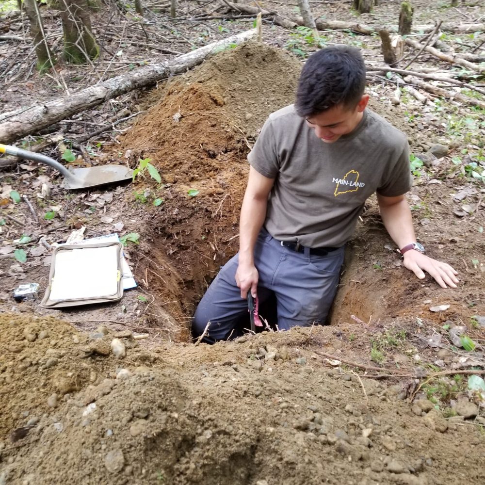 Septic Design Maine Man in pit Main-Land Employee doing a soil test for septic design